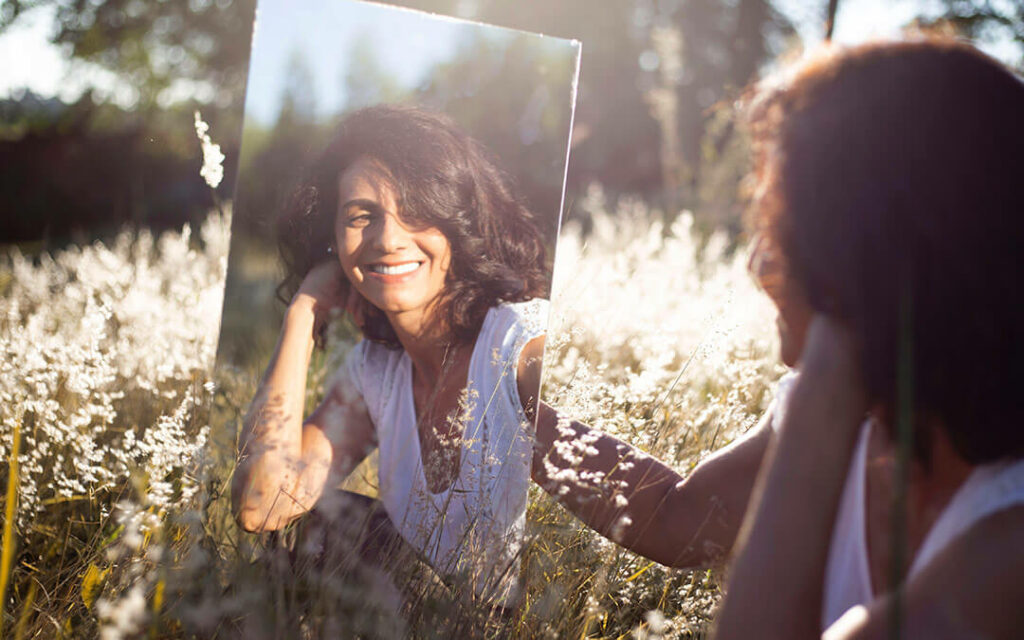Woman looking at herself in the mirror and smiling