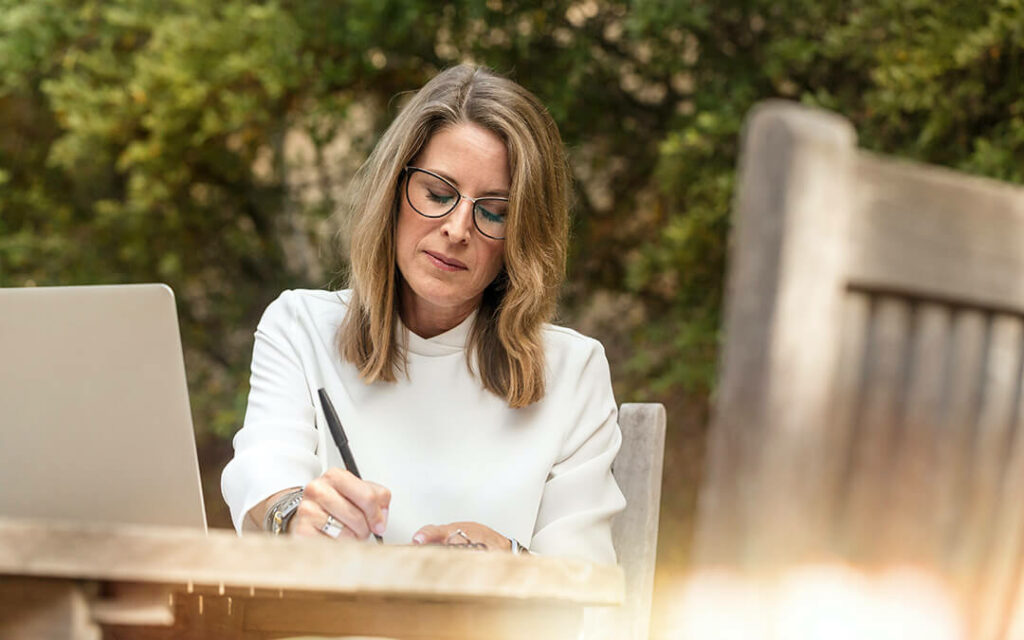 Woman sitting at table writing notes