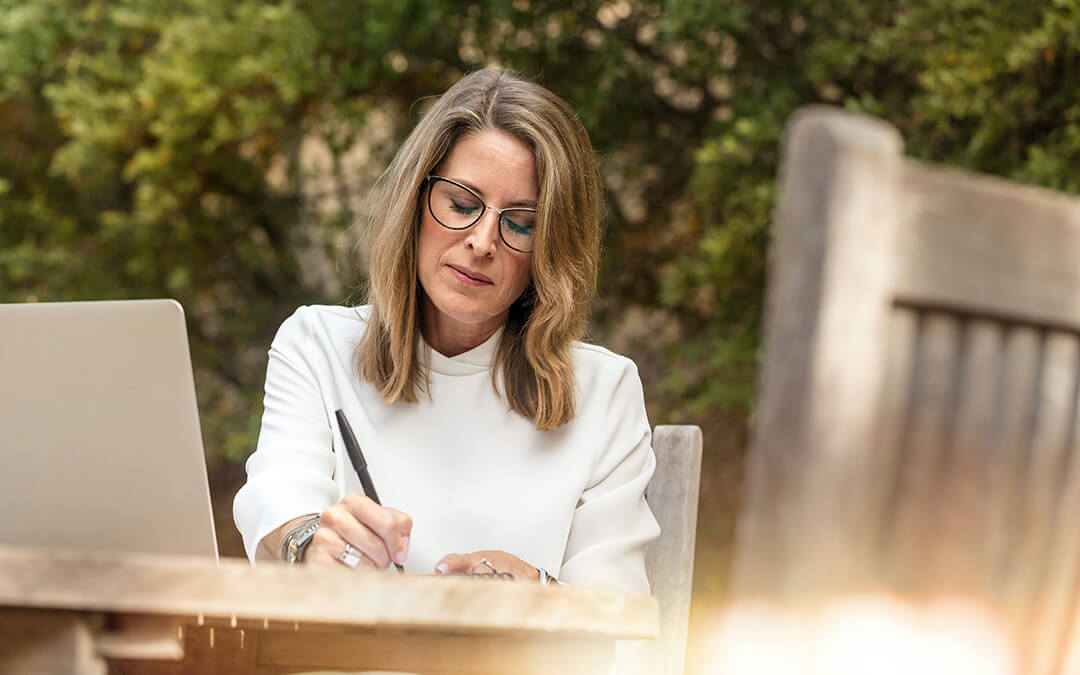 Woman sitting at table writing notes